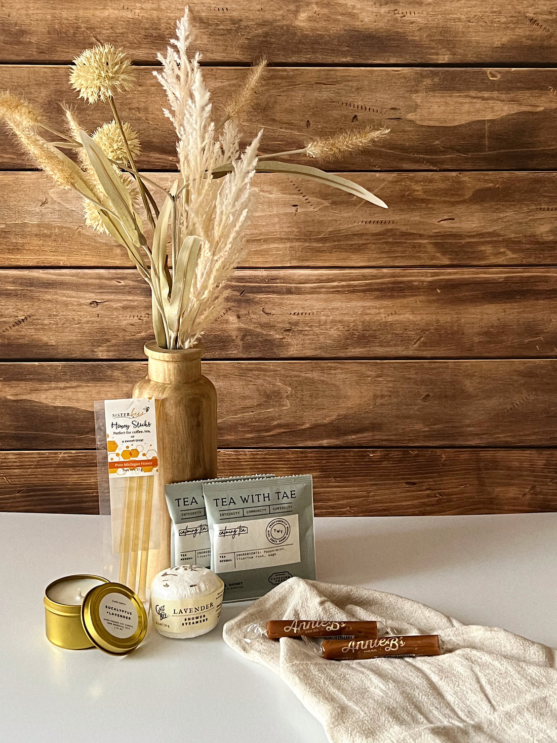 Mini Moment Crate featuring lavender soy candle, calming tea sachets, honey sticks, luxurious shower steamers, and Annie B’s caramels, beautifully arranged with a cozy, rustic aesthetic.